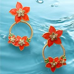 two rings with flowers on them are floating in the water and one is gold plated