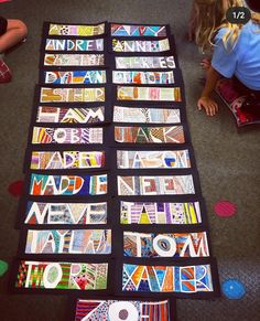 children are sitting on the floor with their art work laid out in front of them