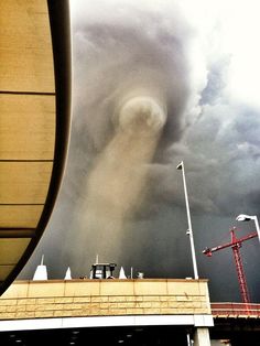 a very large cloud in the sky over a building