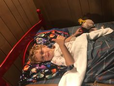 a little boy laying in bed with his stuffed animal and blanket on top of him