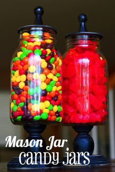 two glass jars filled with candy sitting on top of a table