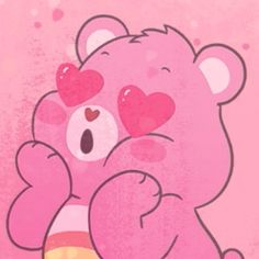 a pink teddy bear with hearts on its face and arms, sitting in front of a pink background