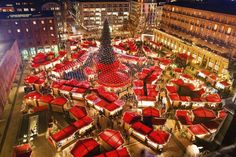 a large christmas tree in the middle of a city with lots of lights on it