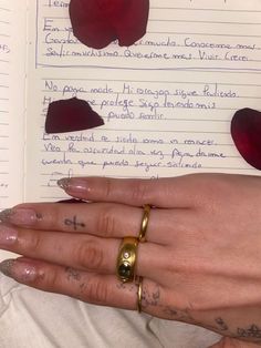 a woman's hand holding an open book with writing on it and apple slices