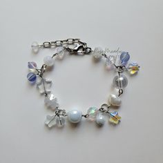 "Handmade Dreamy Pearl Bracelet ✿ Made with glass crystal beads, freshwater pearls, glass beads, and metal accents ✿ Colors: Silver, milky white, iridescent white, royal blue, clear, and pearlescent white ✿ The bracelet has an additional 1-1.5\" of extension chain" White Beaded Bracelets With Pearl Charm, White Metal Pearl Bracelet With Round Beads, White Beaded Crystal Pearl Bracelet, White Beaded Metal Crystal Bracelet, White Beaded Pearl Charm Bracelet, White Beaded Charm Bracelet Bangle, Whimsical White Handmade Charm Bracelet, Adjustable White Crystal Pearl Bracelet, Pearl White Adjustable Pearl Charm Bracelet