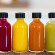 four bottles filled with different colored liquids