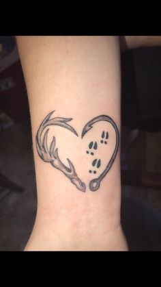 a dog paw and heart tattoo on the wrist