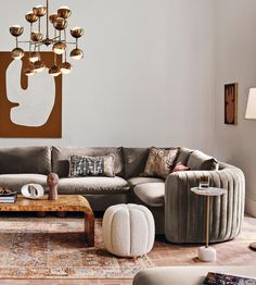 a living room filled with furniture and a chandelier hanging over the couches