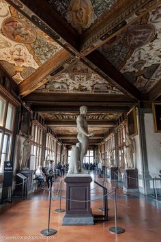 the inside of a building with statues and paintings on the walls