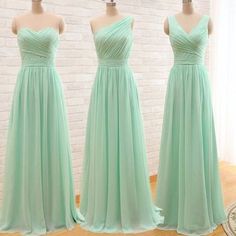 three bridesmaids in mint green dresses standing next to each other on mannequins