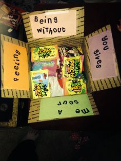 a box filled with candy sitting on top of a table next to a person's feet