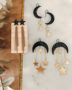 three pairs of stars and moon earrings on a table