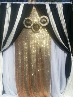 the backdrop is decorated with gold sequins and black drapes