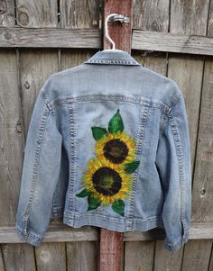 a denim jacket with sunflowers painted on it