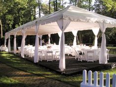 a large white tent set up with tables and chairs