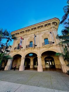 an old building with palm trees in front of it