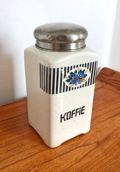 a koffe canister sitting on top of a wooden table