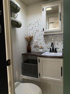 a white toilet sitting next to a bathroom sink