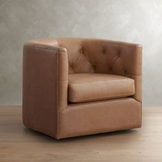 a brown leather chair sitting on top of a wooden floor