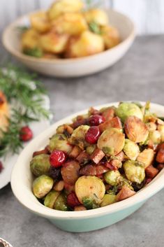 a bowl filled with brussel sprouts and cranberries on top of a table