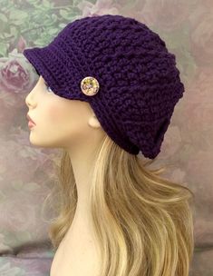 a mannequin head wearing a purple knitted hat with a button on it