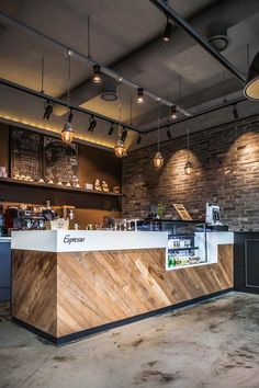 the interior of a coffee shop with brick walls and exposed ceiling lights hanging from the ceiling