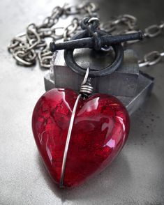 Heart of darkness. Perfect gift for the not-so-girly-girl. Forget the sticky-sweet heart... this has edge. A gloriously-glossy glass heart pendant in sultry, regal red has been wrapped and bound in oxidized sterling silver wire and suspended from a matte black toggle clasp and large-link antiqued silver plated chain. Please note that each heart is slightly different, but each one is gorgeous! Deep red glass heart pendant: approx. 1" wide & tall (25mm) Pendant length: 1-3/4" including toggle ring Red Heart Pendant Necklace, Red Heart Pendant, Red Goth, Heart Of Darkness, Tough Girl, Dark Blood, Dark Heart, Skull Necklace, Sweet Heart