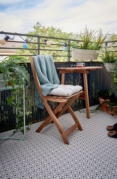 a wooden chair sitting on top of a patio next to a table