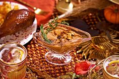 an assortment of desserts and drinks on a table with autumn decorations in the background