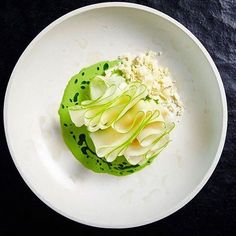 a white plate topped with food on top of a black table