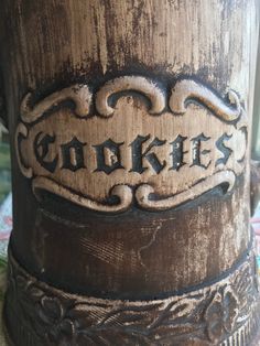 an old fashioned wooden cup with the word cookies carved into it's sides and bottom