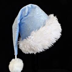 Pastel blue is the color of this panne velvet Santa hat.  It is fully lined with cotton fabric and there is a soft and fluffy white faux fur trim turn up band accent.  The hat styled in the classic slouch Santa stocking hat, generously sized to fit teen and adult head sizes.  Measurement of the hat band is 24-25" circumference and the length of the hat is 20". There is a snowy white faux fur pompom dangle on the hat. Christmas Holiday Party, Stocking Hat, Santa Stocking, Saint Nicolas, Bleu Pastel, Saint Nicholas, White Faux Fur, Costume Hats, Party Hat