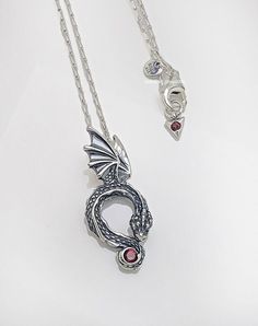 DESCRIPTION: STYLE:       Game of Thrones Dragon Pendant Necklace COLOR:       Silver/Red SIZE:           45 cm CONDITION:   brand new in retail condition. Guarantee Authentic PANDORA Brand  DETAILS: Face the elements with the Game of Thrones Dragon Pendant Necklace. Made of sterling silver, this adjustable-length necklace's pendant portrays a Game of Thrones dragon curled up with its wings spread and tail wrapped around a red man-made crystal. Another red crystal sparkles from the end of the pendant necklace chain. Wear this dragon pendant as a symbol the great and powerful mysteries of the world – both fictional and real. ----Pandora Warranty card, shopping gift bag and gift wrapping service are available at additional cost upon request. This product will be shipped in just plastic bag i Luxury Red Sterling Silver Necklace, Collectible Pendant Necklace With Sterling Silver Clasp, Red Symbolic Sterling Silver Necklace, Targaryen Jewelry, Game Of Thrones Jewelry, Mysteries Of The World, Game Of Thrones Dragons, A Game Of Thrones, Dragon Necklace