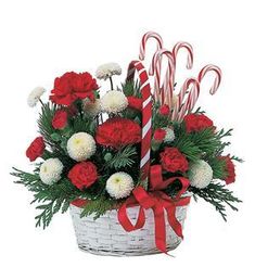 a basket filled with candy canes and flowers