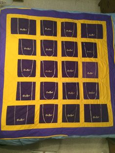 a purple and yellow quilt on a bed with white writing that says, necklaces