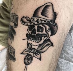 a skull with a hat and tie on his leg is shown in this tattoo design