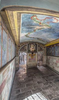 this is an image of a hallway with murals on the walls and ceiling in different colors