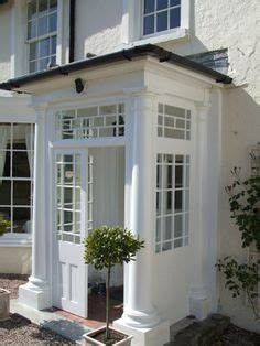 a white house with windows and plants in the front yard