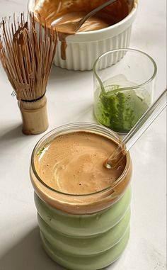 a jar filled with liquid sitting on top of a table next to other bowls and whisks