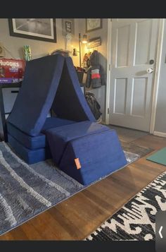 a blue chair sitting on top of a wooden floor next to a door and rug