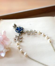 Navy Blue Rose Flower Antiqued Brass Leaf Beaded Pearl Necklace. This nature and vintage inspired necklace is crated from genuine Swarovski pearls, detailed antiqued brass leaf sprigs and a unique navy blue resin flower. The flower has amazing details with beautiful hand-painted gold tipped petals. Swarovski pearls: cream color, 6mm Navy blue resin flowers: 18mm Chain: antiqued brass cable chain with a lobster clasp ♥ Matching bracelet: www.etsy.com/lechaim/listing/399692729 ♥ Matching earrings: Pearl Necklace Gold, Gold Tips, Inspired Necklace, Blue Bridal, Pearl Cream, Matching Bracelet, Woodland Wedding, Resin Flowers, Swarovski Pearls