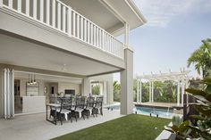 an outdoor dining area next to a swimming pool and covered patio with sliding glass doors