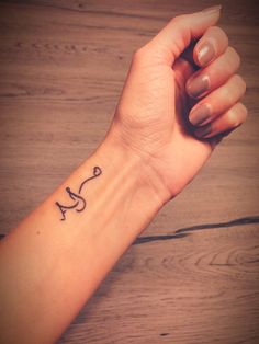 a woman's wrist tattoo with the word love written in cursive writing