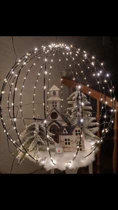 a lighted christmas decoration with a house in the background