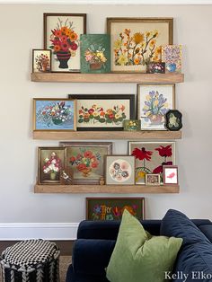 a living room filled with furniture and framed pictures on the wall above it's shelves