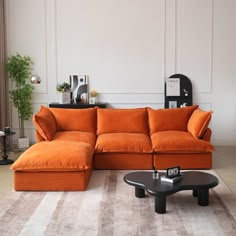 an orange couch sitting on top of a rug in a living room