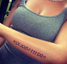 a woman with a roman numeral tattoo on her arm