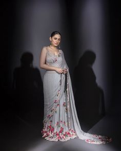 a woman in a grey sari with flowers on it