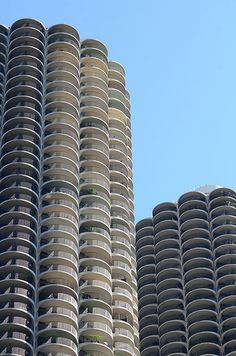 two very tall buildings next to each other in front of a blue sky with no clouds