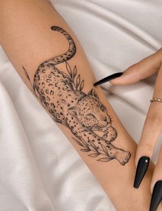 a woman's arm with a tattoo of a leopard on it